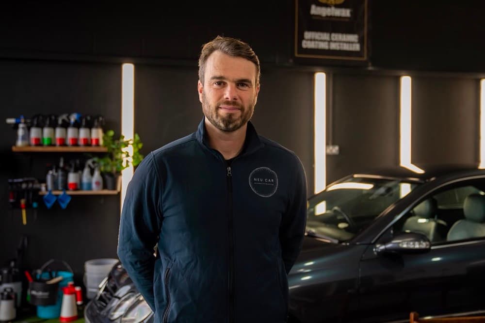 Mike, founder of Neu Car Detailing, in the studio beneath the Angelwax accredited installer sign