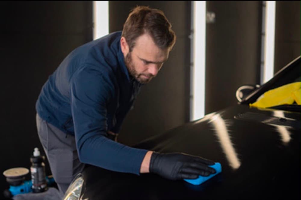 Buffing polish residue off black paintwork with a microfibre cloth