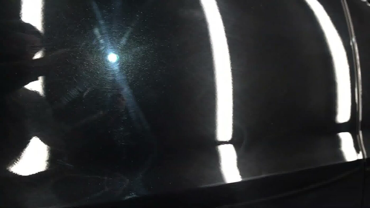 Heavy swirl marks on black paint under direct light
